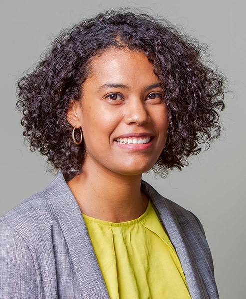 Headshot of Carine Schermann in yellow shirt with gray blazer